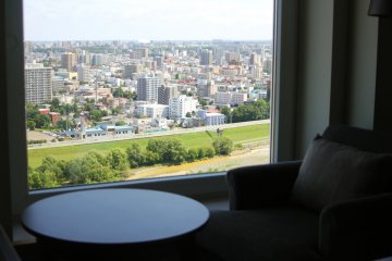 <p>Melihat lanskap kota dari kamar hotel</p>