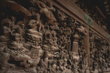 <p>Intricately carved walls based on Lotus Sutra, inside the temple</p>