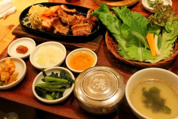 나는 양상추, 마늘, 김치와 다른 반찬을 포함한 삼겹살 세트를 주문했다