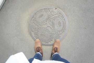 <p>Manhole kota Zama yang berlambang bunga matahari</p>