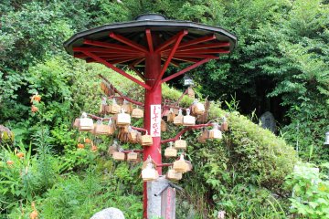 <p>Wooden emma tablets with wishes hanging from a wooden parasol</p>