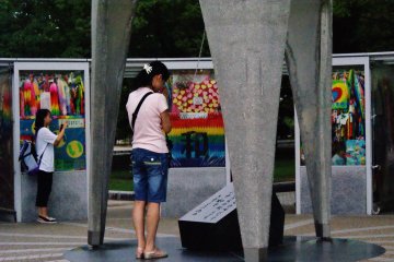 <p>Une jeune fille prie devant le Monument de la paix des enfants apr&egrave;s avoir fait retentir la cloche</p>