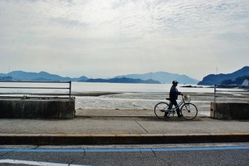 <p>Un monsieur et son v&eacute;lo sur le bord de route</p>