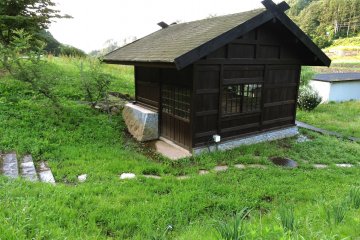 Stepping stones lead to a small waterwheel house
