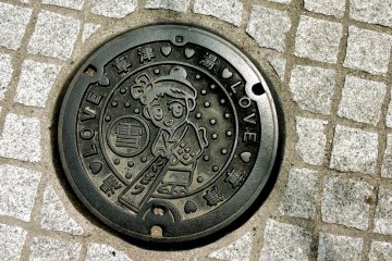 <p>Manhole cover featuring Kusatsu Onsen's mascot, Yumomi-chan</p>