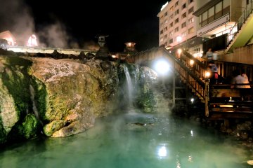 <p>Lights reflect in the turquoise pool at one end</p>