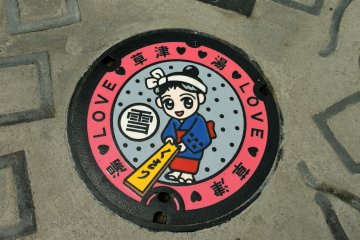 <p>Tutup saluran air menunjukkan&nbsp;Yumomi-chan, maskot Kusatsu Onsen&nbsp;</p>