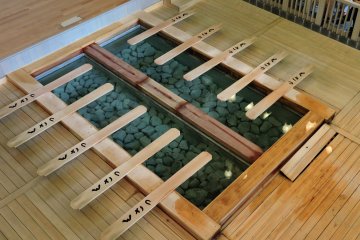 <p>Dayung kayu beristirahat di samping kolam air panas</p>