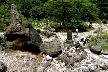 Sur les rochers, des statues et des monuments surplombent le bassin pour pieds