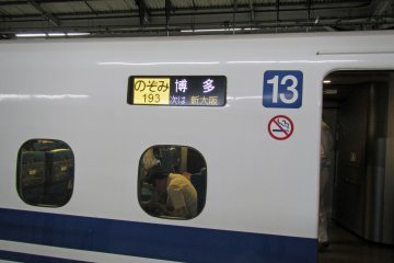 <p>The destination and service display of the Shinkansen I rode. The Tokaido-Sanyo Shinkansen has three services: the Nozomi, Hikari and Kodama services. The pictured Nozomi service is written in yellow and stops at only the most major stations and run all the way from Tokyo to Hakata at the end of the line. Hikari Shinkansen services are written in red, they stop at the same major cities as the Nozomi plus select cities between them (check the train displays for the detailed stop list), and they terminate sooner than Nozomi services (often in Okayama) Kodama Shinkansen services are written in blue and stop at all Shinkansen stations between Tokyo and Shin-Osaka. Kodama services terminate at Shin-Osaka</p>