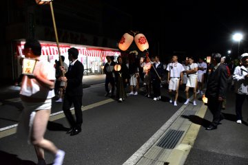 <p>Lion bearers marching down the street at night</p>