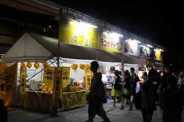 <p>Kios-kios di festival makanan dan bir tersedia di luar Aula Kasugano International Forum</p>