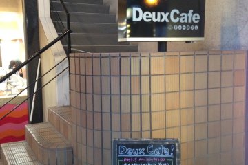 <p>Tampak depan Deux Cafe, Anda akan menaiki tangga terlebih dahulu untuk masuk ke dalam restorannya.</p>