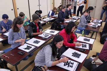 <p>Foreign and Japanese visitors to the museum try their hand at sumo calligraphy &nbsp;</p>