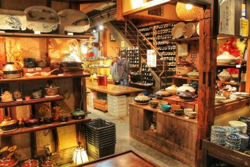 <p>Next to the stairs is a shelf full of different rice bowls</p>