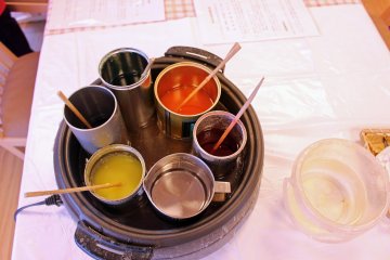 <p>Beragam pot bahan lilin cair. Pot bahan lilin bening di bagian bawah digunakan untuk menyelesaikan dan menutup pembuatan lilin.</p>