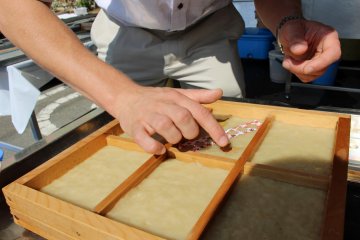 <p>Dekorasi diletakan di atas kertas. Air dari bubur kertas akan merekatkan dekorasi dengan sendirinya.</p>