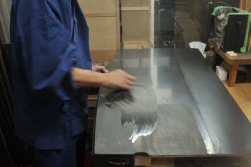 <p>Black paint is applied on a piece of wood.</p>