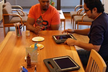 <p>Two visitors conduct research on an English language table</p>