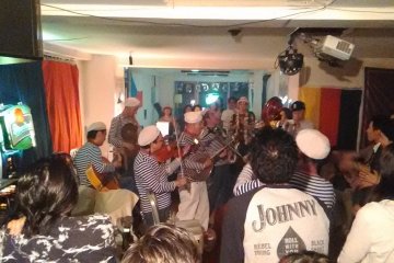 <p>An at capacity crowd huddles around the lively band</p>