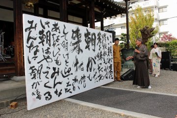 <p>The finished calligraphy is explained by the head of the neighborhood association</p>