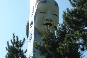Statue of Noh mask by the terminal building in Ryotsu Port