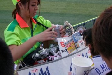 A beer vendor busy keeping the thirsty fans happy.