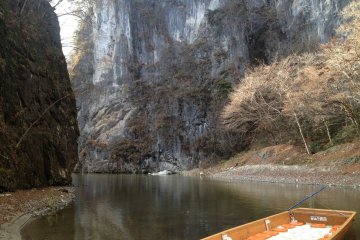 <p>Boat parked in the middle of towering limestone walls.</p>