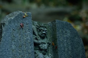 A statue covered in fallen autumn leaves