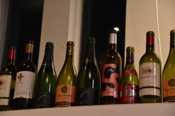 <p>Empty wine bottles lining the wall shelf</p>
