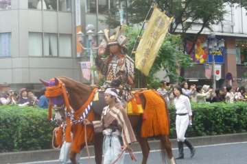 Samurai on horseback parading through the city streets