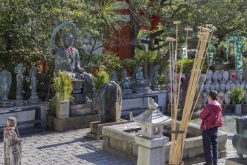 Una mujer reza al Jizō Bodhisattva para cuidar las almas de los infantes