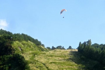 An expert pilot overflies the intermediate flying field while a student waits for the right wind conditions