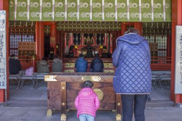 Mother and daughter pray before the main worship hall