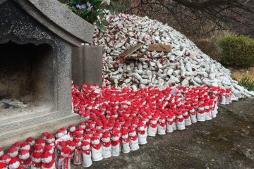 On peut écrire une prière sur une des mini statues coiffées de rouge
