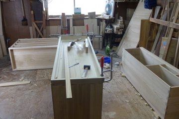 Wooden planks are assembled into the shape of a chest of drawers