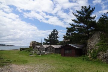 Storage huts belonging to fishermen hidden behind some large rock formation