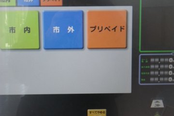Layar pembuka pada mesin tiket. Warna hijau menunjukan bahwa Anda tinggal atau sedang belajar di Utsunomiya. Tekan tombol biru jika sebaliknya. Tombol oranye digunakan untuk membeli kartu tiket prabayar.