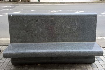 A granite bench with manga characters