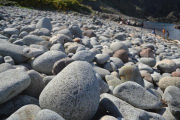 A rocky beach awaits at the base.