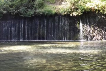 <p>The water collects in a clear pool before spilling down the slope</p>