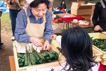 Street stalls selling mochi wrapped in leaves.