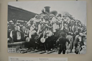 People cling to a train leaving Tokyo