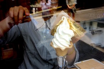 A careful pair of bamboo tongs helps the thin sheet of gold leaf hug onto the ice-cream