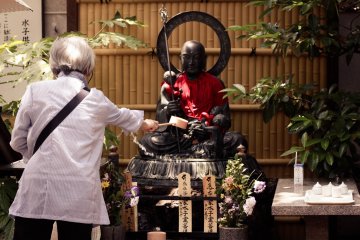 Menyiram Buddha untuk penyucian 