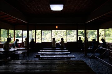 Des visiteurs se reposant dans le pavillon du jardin Keitaku-en