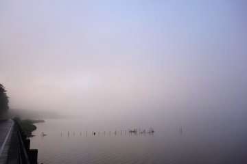 The glassy surface of the lake blurs the horizon in the distance, making it hard to distinguish sky and water