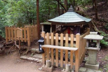 Yoshitsune Sekurabe ishi to the left and a mini-shrine for worship to the right