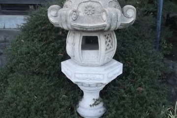 An unusual lantern with a ribboned gourd on top