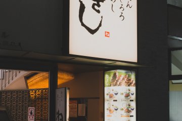 Signboard seen from outside, with steep stairway on the left